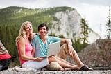 Relaxed couple with laptop while camping