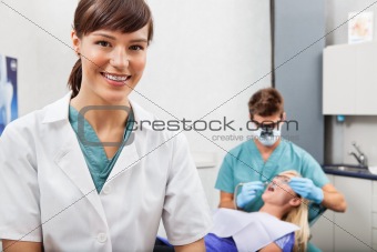Assistant with dentistry work in the background
