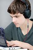 Teen Wearing Headphones Works On Computer