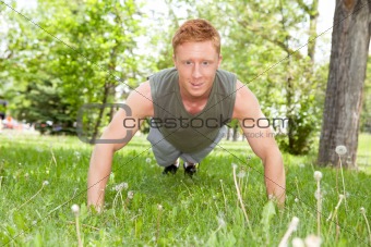 Man doing a push up in park
