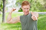 Man flexing and showing thumbs-up sign