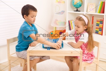 Siblings playing chess in the kid's room