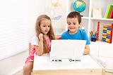 Two kids looking at laptop computer