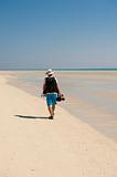 Photographer walking on a tropical beach