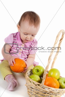 Shot of baby girl in pink with fruits