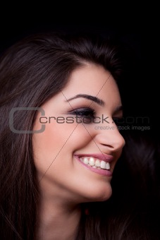 Young woman smiling, on black background
