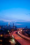 Light trail at busy highway with the view of kuala lumpur city