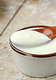 fresh natural yoghurt in a ceramic cup on wooden table