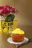 cupcake with yellow cream on a wooden table