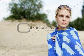 Portrait of a young beautiful girl on the beach. She is upset