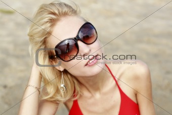 Portrait of a young beautiful girl with glasses on the beach