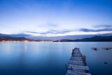 a romantic blue sunset with a jetty over a lake with an evening glow 
