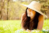 Beautiful brunette girl in hat at the park.