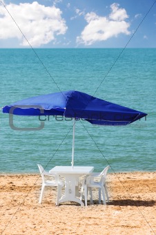 Table, chairs and parasol on  the beach