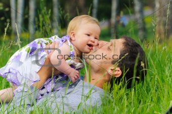 Happy father with daughter resting in the grass