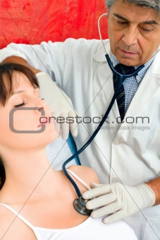 man doctor visits a young caucasian woman with stethoscope