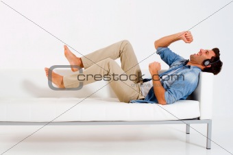man on the couch listening music with headphones