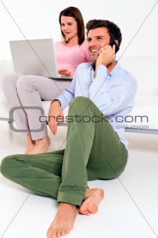 woman with laptop and man with mobile