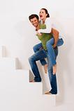 man climbing the stairs with woman on his shoulders