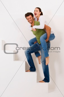 man climbing the stairs with woman on his shoulders