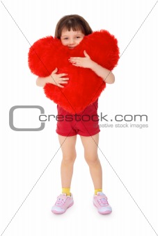 Little girl hugging a toy heart on a white
