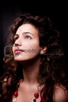 Young and attractive woman looking up smiling, isolated on black, studio shot