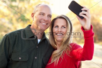Happy, Attractive Couple Pose for a Self Portrait Outdoors.