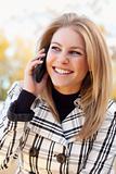 Pretty Young Blond Woman on Her Cell Phone Outside on Fall Day.