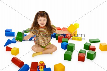Little girl playing with color cubes on floor