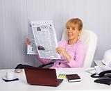 Young woman reads news on the workplace