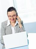 smiling young business woman with glasses using laptop