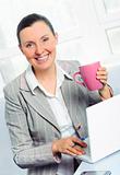 smiling young business woman with cup using laptop