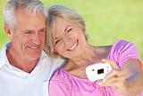 Happy Senior Couple Taking Self Portrait Photograph on Digital C