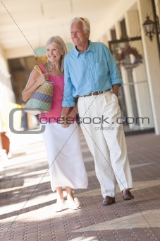 Happy Senior Couple Holding Hands in Shopping Mall