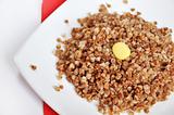 Appetizing crumbly buckwheat with butter on white background