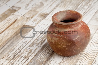 red clay pot on rustic table