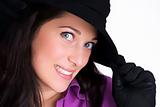 Portrait of a beautiful young woman with gloves and black hat