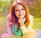 Redhead girl at grass in the park. Photo in multicolor style.