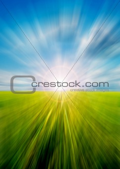 Abstract motion blurred meadow and sky with sun