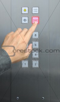 businessman hand press close door button in elevator