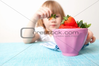 Little girl with a bowl of strawberries