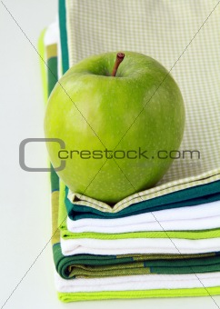 Pile of linen kitchen towels with green apple