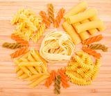 Different kinds of italian pasta on the wooden background 