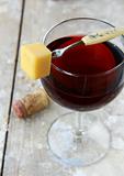 A glass of red wine with a slice of cheese for a snack