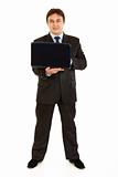 Full length portrait of smiling modern businessman using laptop
