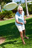 Happy Senior Man Throwing Frisbee Outside in Sunshine