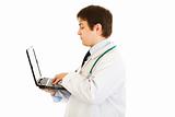 Serious medical doctor  working on laptop
