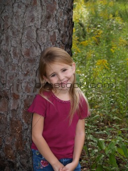 Young girl Leaning Against Tree