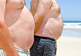 Close up of two obese fat men of the beach