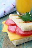 breakfast sandwich with cheese and salami and juice